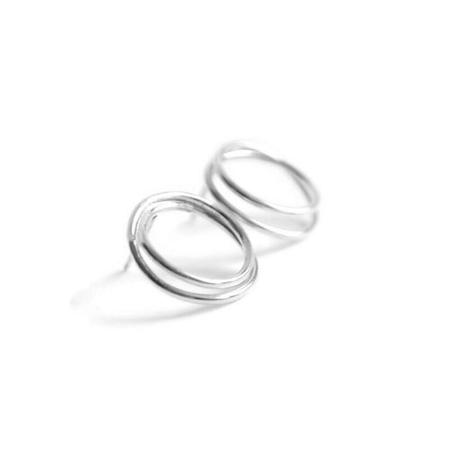 Pair of minimal silver hoop earrings on a white background